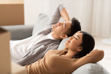 Asian couple lying on new sofa and sleeping