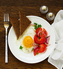 Fried egg with tomato salad. Healthy breakfast. Selective focus