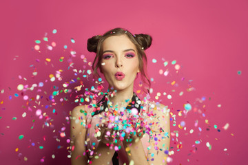 Birthday party background with beautiful girl blowing colorful confetti
