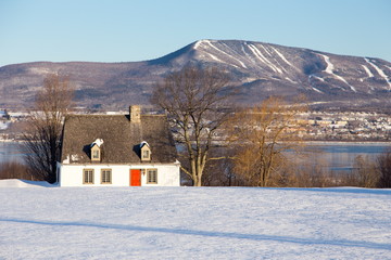 Beautiful early morning winter view of patrimonial white wooden house with steep shingled roof in...