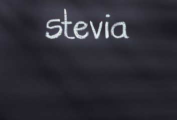 Stevia phrase written in chalk on rustic surface - Stevia rebaudiana