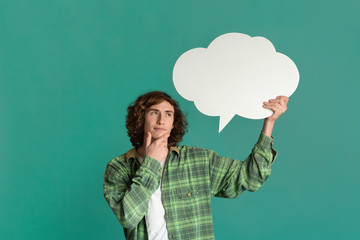 Dreamy millennial guy with speech bubble deep in thought on color background, space for text