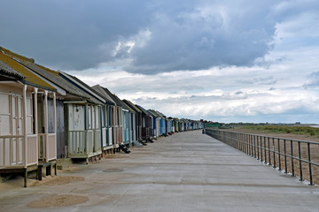 row of beach houses in front of the beach with a cloud sky