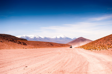 Fototapeta na wymiar Off-road cars driving on the road in the desert on plateau Altiplano, Bolivia. South America landscapes