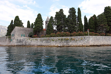 Saint George monastery stone walls flowers and trees Perast Bay of Kotor Montenegro