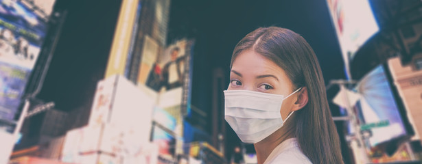 Corona virus NYC travel ban China woman tourist walking in New York city street wearing protective...