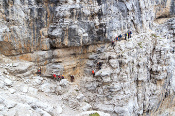 People climbing on via ferrata Sentiero delle Bocchette Centrale in Brenta Dolomites mountains,...