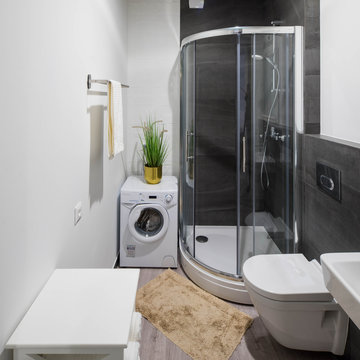 Modern contemporary interior of bathroom with shower cabin. White toilet. Washing machine.