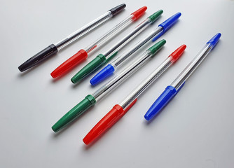 Set of plastic ballpoint pens of different colors with a plastic cover, isolated on a white background, stationery