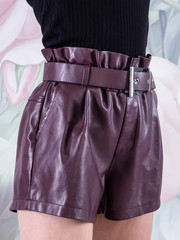Woman wearing purple leather shorts
