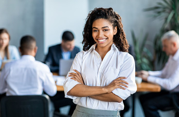 Black Businesswoman Smiling At Camera Posing Standing In Modern Office