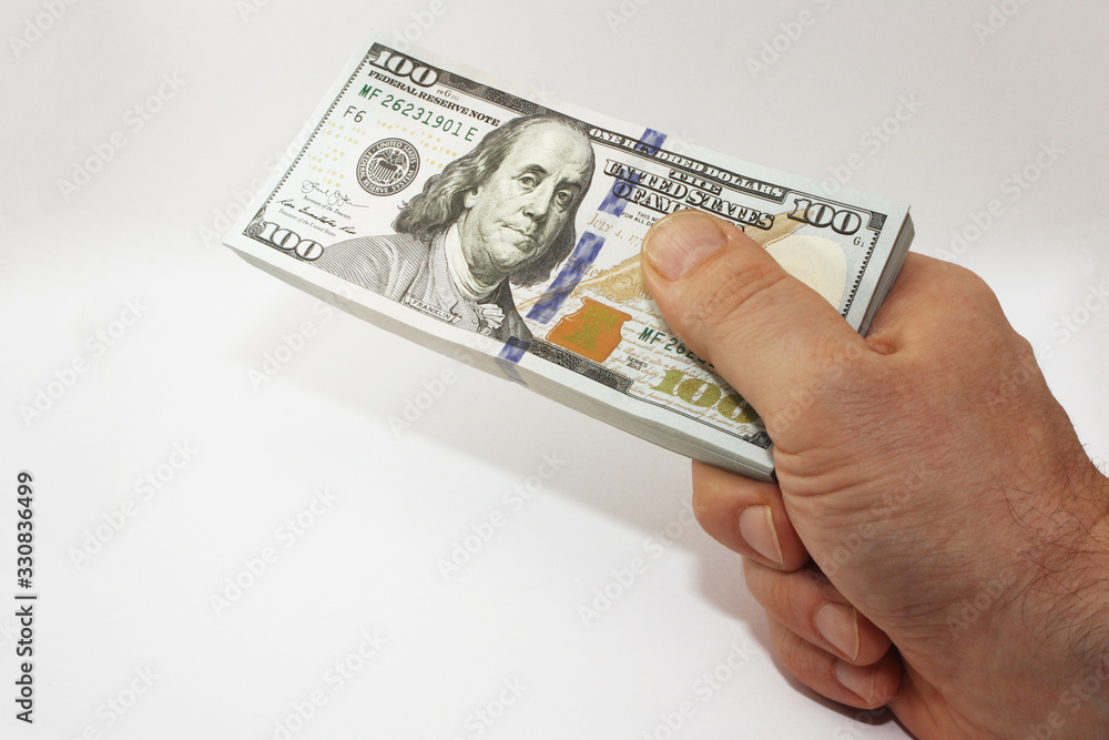 Wall mural stack of american money in hand, one hundred dollar cash banknotes on white background, lot of one h