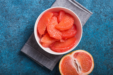 Fresh grapefruit slices in a wooden bowl, healthy snack