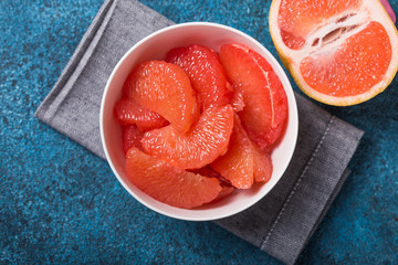 Fresh grapefruit slices in a wooden bowl, healthy snack