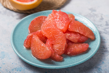 Fresh grapefruit slices in a wooden bowl, healthy snack