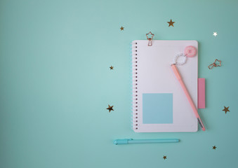 Flat layout of notepad with pink and mint accessories
