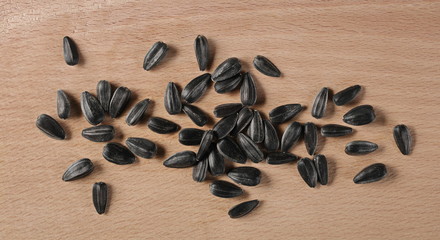 Fototapeta na wymiar Sunflower seeds pile on wooden chopping board background and texture