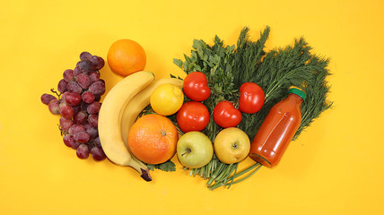 Healthy organic food on a yellow table, healthy lifestyle concept. Vegetables, fruits, grapes, herbs, bananas, citrus fruits, diet ingredients, flat lay, place for text