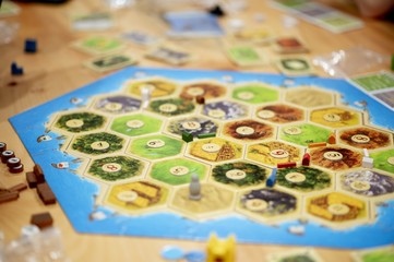 High angle closeup shot of a board game with playing cards on the background