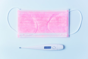 coronavirus 2019-nCoV breathing mask and thermometer showing the temperature of a healthy person as symbol of good health. Flat lay top view.