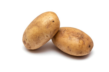 two raw dirty potatoes on a white background