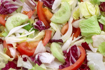 Healthy food. Salad with fresh vegetables - Cichorium endivia, Radicchio, Chicory Pan di zucchero, tomatoes, cucumbers, onions - and olive oil