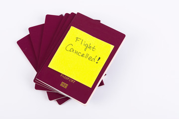 A stack of red passports and Note Flight Cancelled isolated on White Background . Travel concept.