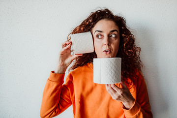 .Young woman hoarding a lot of toilet paper at home. Madness caused by the coronavirus health...