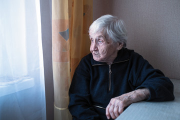 An old depressed loneliness woman in his house looking at nothing.