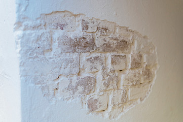 Old brick wall painted in white in the apartment.
