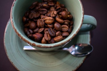 cup of coffee with beans on wooden table