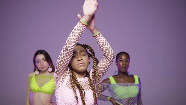 three dancers standing next to each other and middle one stepping towards to show off