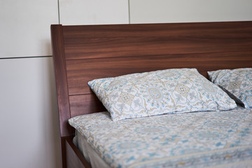 double wooden bed in a minimalistic white bedroom