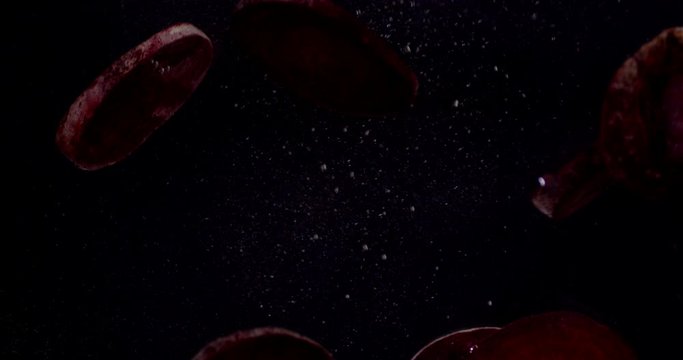 Pieces of fresh beets fall into the water.