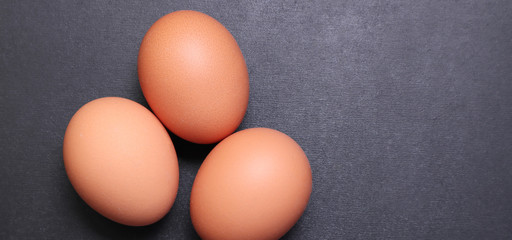Chicken eggs on a black textured background.