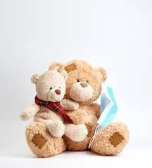 big teddy bear are sitting in blue medical masks on a blue background, concept of protection from respiratory disease