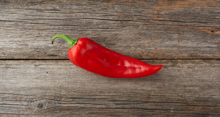 whole red pepper on a gray wooden board