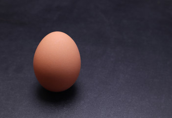 Chicken egg on a black textured background.