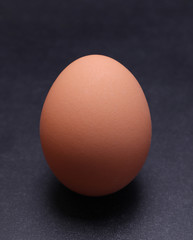 Chicken egg on a black textured background.