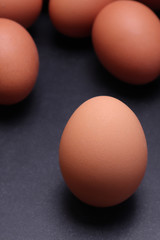 Chicken eggs on a black textured background.