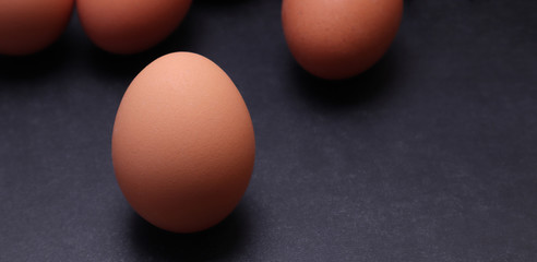 Chicken eggs on a black textured background.