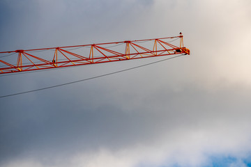 Tip of a construction crane on cloudy storm sky