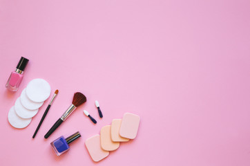 Professional makeup tools. Makeup tools brushes, eyelashes, nail polish, ,cotton pads, applicators on pink  background. Cosmetics for beauty. Top view with copy space Flat lay.