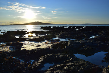 Naklejka premium View of a rock pool in Takapuna, Auckland, out across the sea to Rangitoto volcano