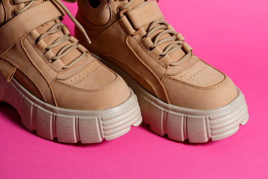 brown leather women shoes with high soles on a pink background. fashion footwear