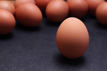 Chicken eggs on a black textured background.