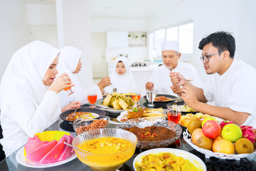Obraz na płótnie Canvas Asian muslim family eating and drinking together