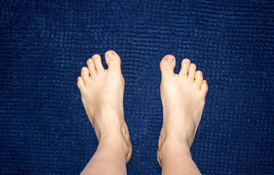 Female Foot On The Dark Blue Carpet. Concept Of Wellness And Hygiene, Copy Space.