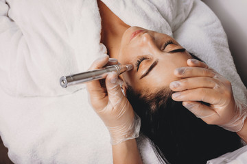 Upper view of ca skin care procedure made with modern apparatus at the spa salon