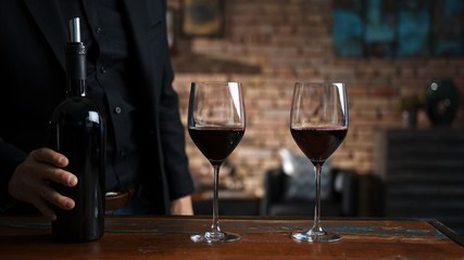 Man tasting and serving red wine at home